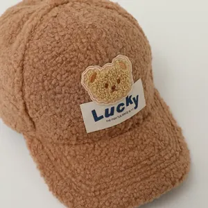 Detail of coffee brown sherpa baseball cap with lucky bear embroidery and soft wool texture