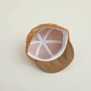 Détail de la sangle réglable et doublure polaire chaude sur la casquette bébé