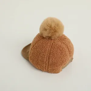 Détail de la casquette d'hiver pour bébé avec pompon en peluche et texture sherpa douce