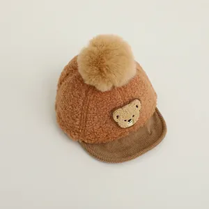 Detailed close-up of baby winter cap featuring brown fleece texture and bear embroidery