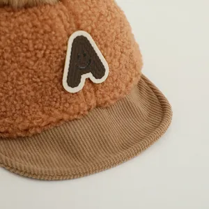 Détail du bonnet d'hiver bébé en polaire peluche marron avec lettre A brodée