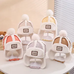 Detailansicht von fünf farbigen Kinder-Wintermützen mit Bommel und warmem Futter