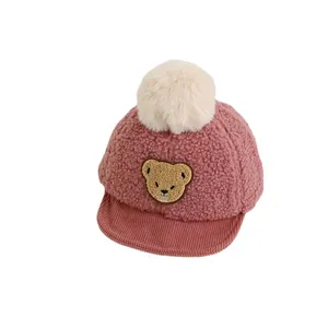 Pink fleece baby baseball cap featuring a cute cartoon bear and soft faux fur pom-pom