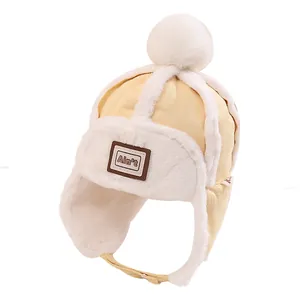 Gelbe Kinder Winter-Fliegermütze mit weißem Kunstfellfutter und Bommel-Detail