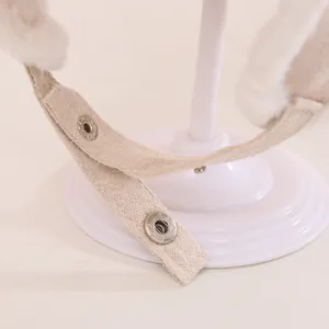 Detail of adjustable metal snap fastener on plush fleece and suede earflap hat strap