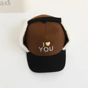 Detalle de gorra de invierno de pana con orejeras de felpa y bordado de amor