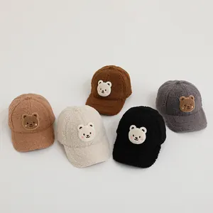 Detailed arrangement of five sherpa fleece baseball caps with cute bear patches in various colors