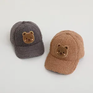 Detailed view of warm lamb wool baseball caps with cute embroidered bear patches for kids