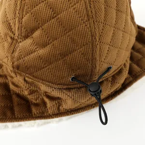 Detail of winter trapper hat showing brown quilted fabric and soft fleece lining