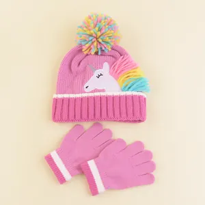 Detail of pink knitted unicorn hat and mittens set with colorful pompom for girls