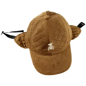 Brown quilted winter trapper hat for children featuring ear flaps and bear embroidery