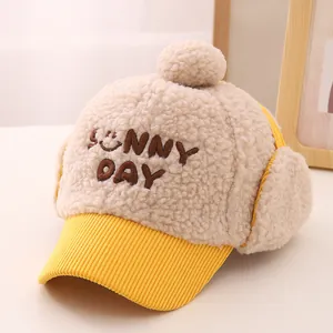 Detail of warm winter hat showing plush beige faux fur and yellow corduroy texture
