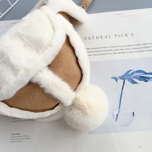 Dettaglio del cappello invernale in camoscio cammello con fodera in pelliccia e pompon