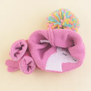 Pink knit unicorn baby hat and mittens set with colorful pom-pom for girls' winter warmth