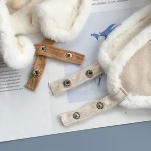 Dettaglio cappello invernale con bottoni a pressione argento e bordo in ecopelliccia