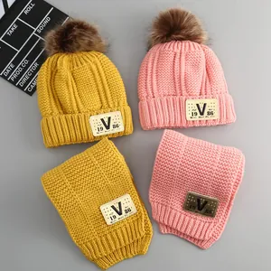 Winter baby knitted beanie and scarf set with V-label and fluffy faux fur pom-poms