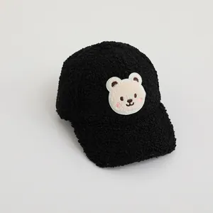 Detail of black sherpa fleece baseball cap with cute embroidered cartoon bear patch
