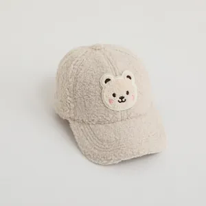 Detailed view of beige faux shearling baseball cap with a cute bear embroidery patch