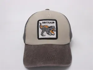 Detail of cartoon dinosaur patch and contrast brim on washed cotton kids baseball cap