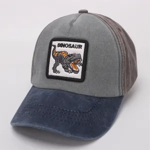 Detail of children's baseball cap featuring a dinosaur embroidery patch and two-tone fabric