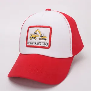Detail of red and white trucker cap featuring embroidered yellow excavator and truck patch