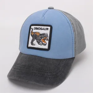 Detail view of cartoon dinosaur embroidery patch on blue and grey baseball cap