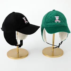 Detalle de gorro de invierno de pana con forro de borreguillo y bordado de osito suave