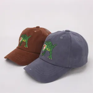 Detail of embroidered green dinosaur on brown and grey cotton baseball caps for kids