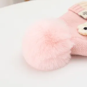 Nahaufnahme der rosa Strickmütze mit flauschigem Kunstpelz-Pompon und weicher Textur