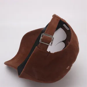 Detail of adjustable silver metal buckle and brown corduroy strap on the back of the cap