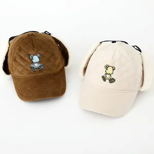 Primer plano de la textura de pana y orejeras de felpa en gorros de invierno infantiles