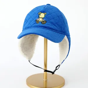 Detalle del gorro acolchado azul con forro cálido de lana de cordero y bordado de osito