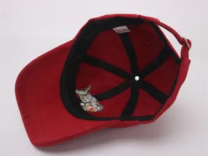 Detail of red cotton kids cap showing inner sweatband, ventilation holes and metal buckle