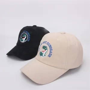 Detail of kids baseball caps in black and beige featuring cartoon dinosaur embroidery