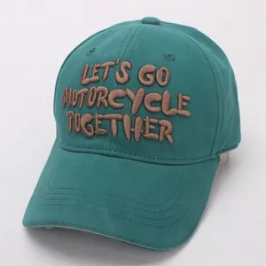 Close-up of teal cotton baseball cap with brown 3D embroidered motorcycle slogan