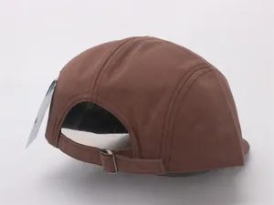 Close-up of brown camper hat back with metal buckle adjustment strap and fabric tag