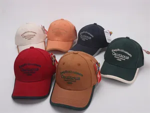 Detailed close-up showing embroidered text on multi-color cotton baseball caps
