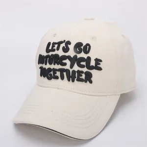 Close-up of cream baseball cap featuring black 3D embroidery and cotton twill texture