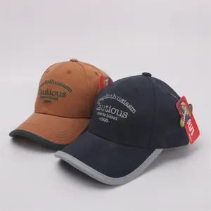 Detail of baseball caps showing premium cotton twill texture and contrast letter embroidery