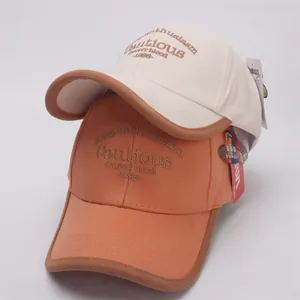 Kids baseball caps in cream and orange with contrast brims and classic embroidery