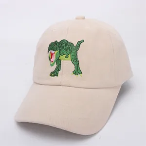 Close-up of a khaki kids baseball cap featuring a detailed green dinosaur embroidery