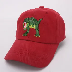 Close-up of red cotton baseball cap with green T-Rex dinosaur embroidery detail