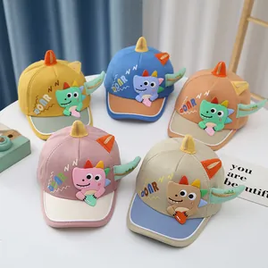 Detail view of colorful cartoon dinosaur baby baseball caps in five vibrant shades