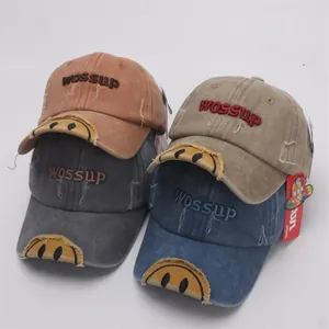 Macro detail of four vintage washed cotton baseball caps with embroidery and smile patch