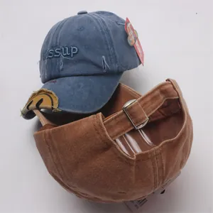 Detail of vintage washed baseball caps featuring 3D embroidery and adjustable metal buckle