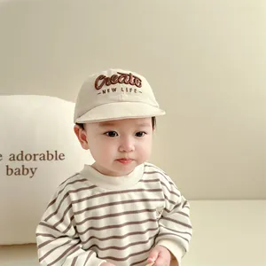 Beige baseballpet voor baby met borduursel en gestreept sweatshirt voor kinderen