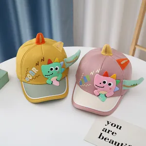 Detail of baby dinosaur baseball caps in yellow and purple with 3D horns and ROAR embroidery