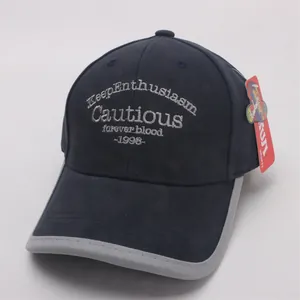 Detailed embroidery and grey contrast piping on a navy blue cotton baseball cap