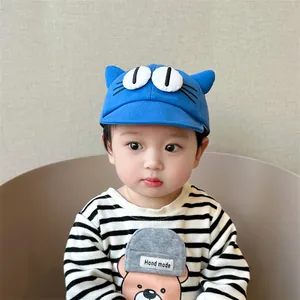 Detailed view of baby cartoon baseball cap with cat ears and embroidered eyes in blue