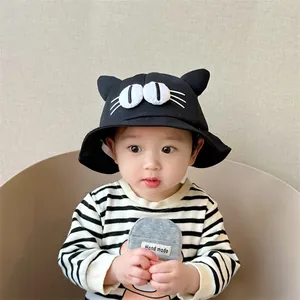 Detail view of a black cotton kids bucket hat with 3D cat ears and cute eye embroidery